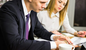 young business colleagues discussing work on a laptop computer in co-working space, corporate businesspeople